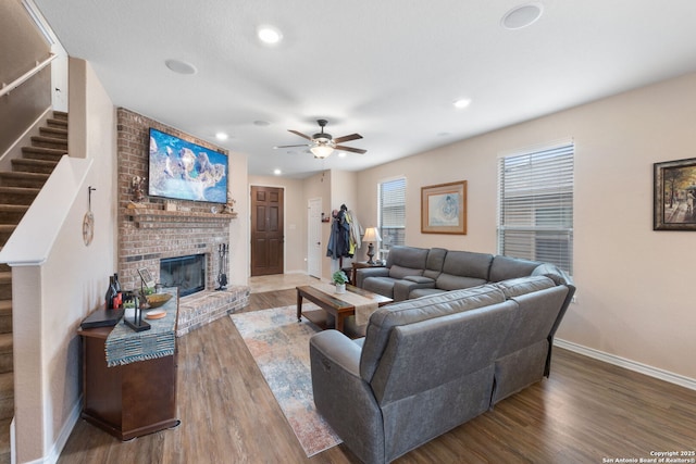 living room with ceiling fan, hardwood / wood-style floors, and a fireplace