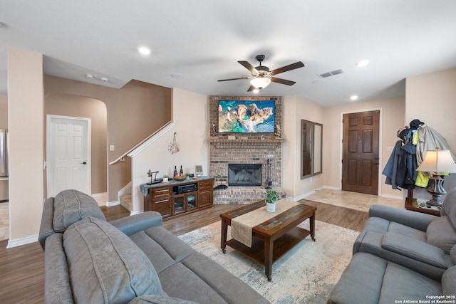 living room with hardwood / wood-style flooring, a fireplace, and ceiling fan