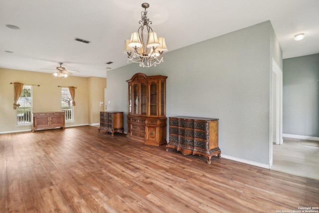 unfurnished living room with hardwood / wood-style flooring and ceiling fan with notable chandelier