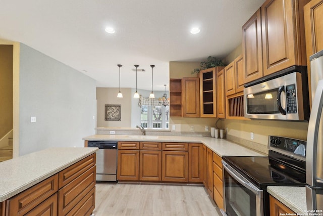 kitchen featuring pendant lighting, sink, light hardwood / wood-style floors, kitchen peninsula, and stainless steel appliances