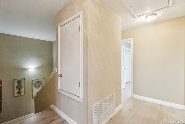 hallway with light hardwood / wood-style floors