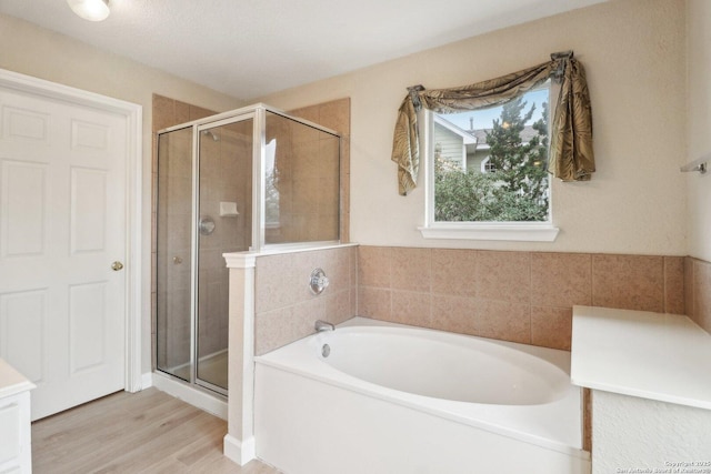 bathroom featuring separate shower and tub and hardwood / wood-style floors