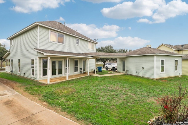 rear view of property with a lawn and french doors