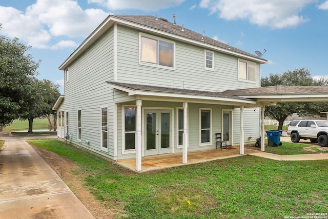 back of house with french doors and a yard