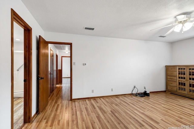 spare room featuring ceiling fan, a textured ceiling, and light wood-type flooring