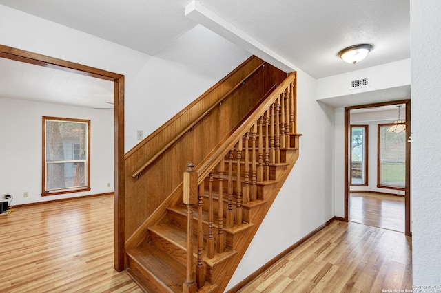 stairway featuring hardwood / wood-style floors and a textured ceiling