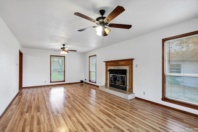 unfurnished living room featuring plenty of natural light, a fireplace, and light wood-type flooring