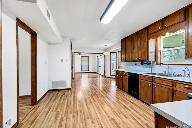 kitchen featuring sink, light hardwood / wood-style flooring, dishwasher, pendant lighting, and a healthy amount of sunlight