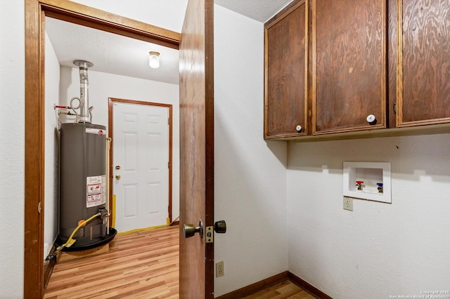 clothes washing area with gas water heater, cabinets, a textured ceiling, washer hookup, and light hardwood / wood-style floors