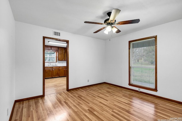 empty room with ceiling fan and light wood-type flooring