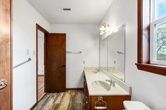 bathroom featuring vanity, toilet, and hardwood / wood-style floors