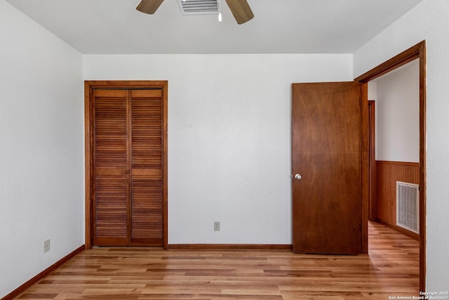 unfurnished bedroom featuring ceiling fan, light hardwood / wood-style floors, and a closet