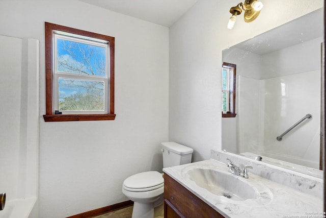 bathroom with vanity, a wealth of natural light, toilet, and walk in shower