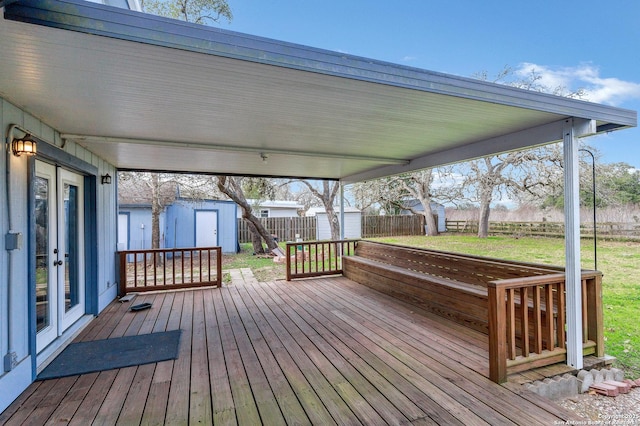 wooden deck with a storage shed and a yard