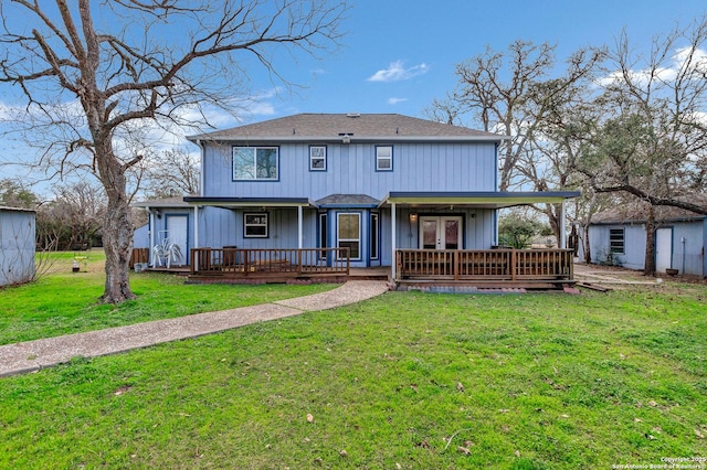 rear view of property featuring a porch and a yard