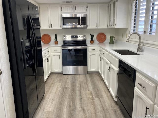 kitchen featuring sink, white cabinets, and black appliances