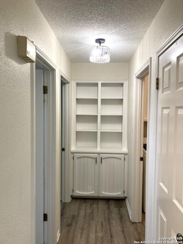 corridor featuring dark wood-type flooring and a textured ceiling