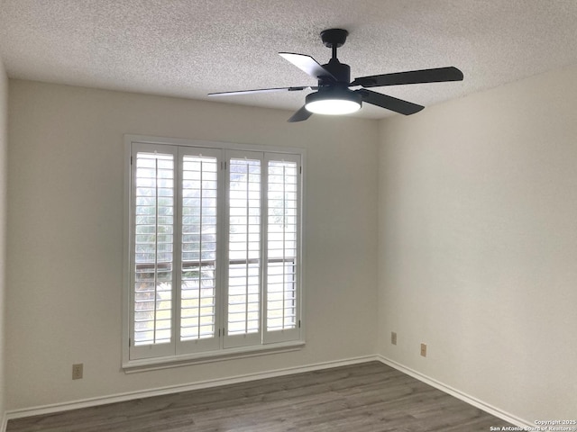 spare room with ceiling fan, dark wood-type flooring, plenty of natural light, and a textured ceiling