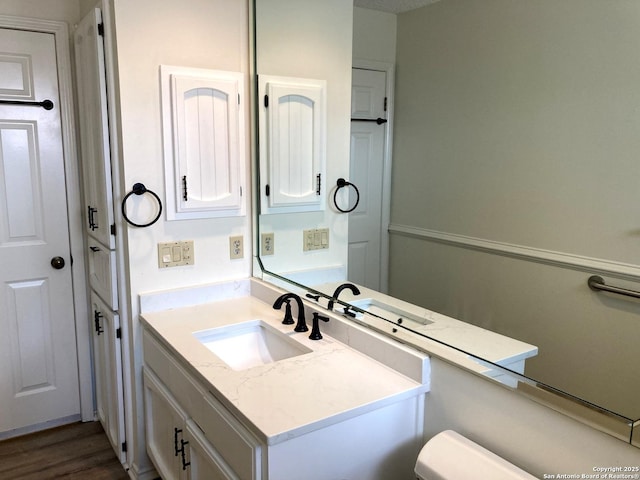 bathroom featuring vanity, wood-type flooring, and toilet