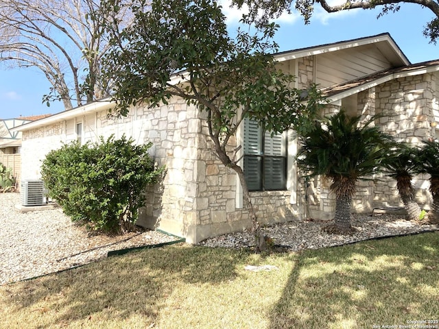 view of property exterior with a lawn and central air condition unit