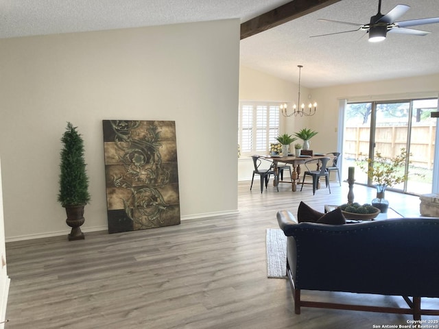 living room with lofted ceiling with beams, a healthy amount of sunlight, hardwood / wood-style floors, and a textured ceiling