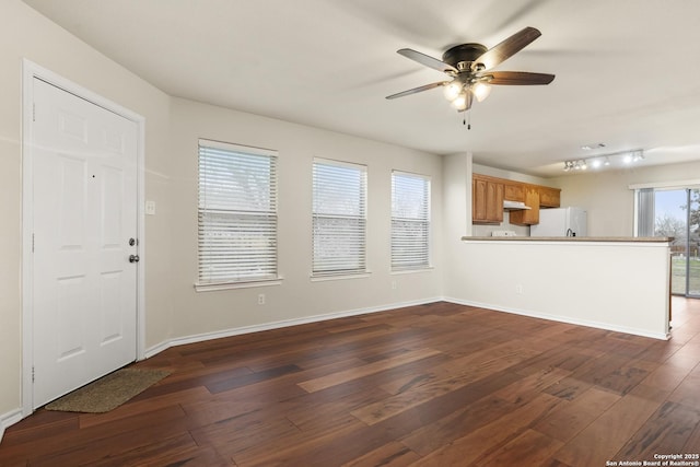 unfurnished living room with ceiling fan and dark hardwood / wood-style flooring