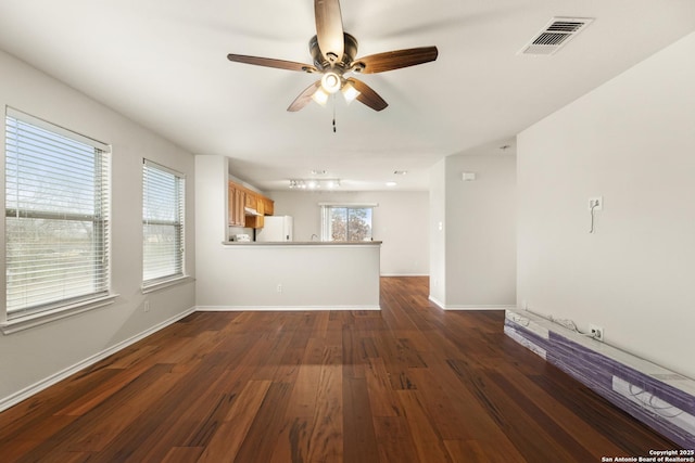 unfurnished living room with dark wood-type flooring and ceiling fan