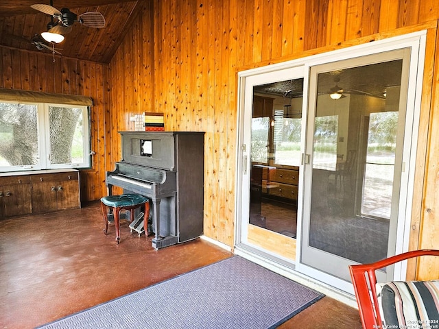 sunroom featuring a ceiling fan, lofted ceiling, and wood ceiling