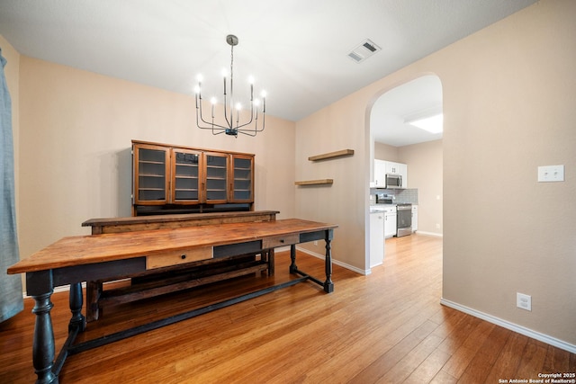 dining space featuring a notable chandelier and light hardwood / wood-style flooring