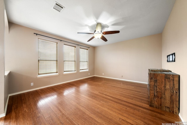 unfurnished room with dark wood-type flooring and ceiling fan