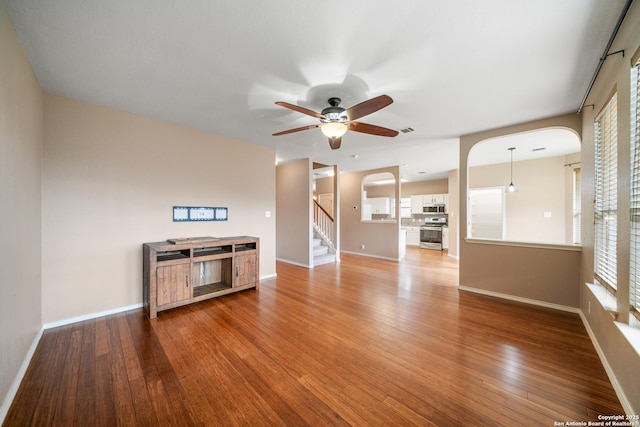 unfurnished living room with hardwood / wood-style flooring and ceiling fan