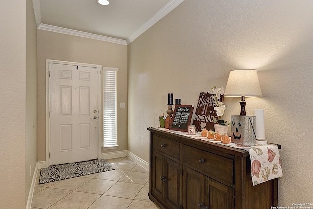 entryway featuring ornamental molding and light tile patterned floors