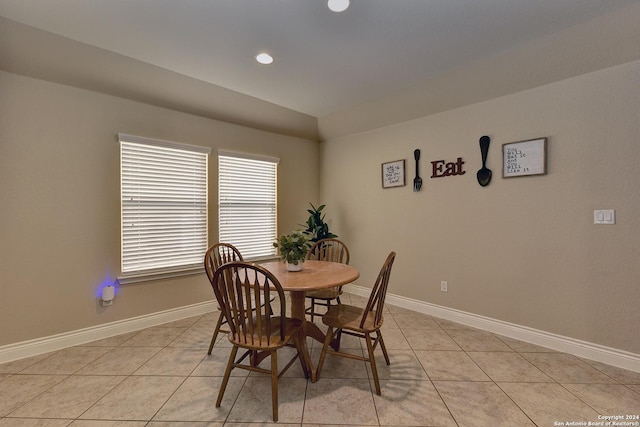 tiled dining room with vaulted ceiling