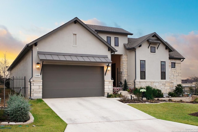 view of front of home with a garage and a lawn