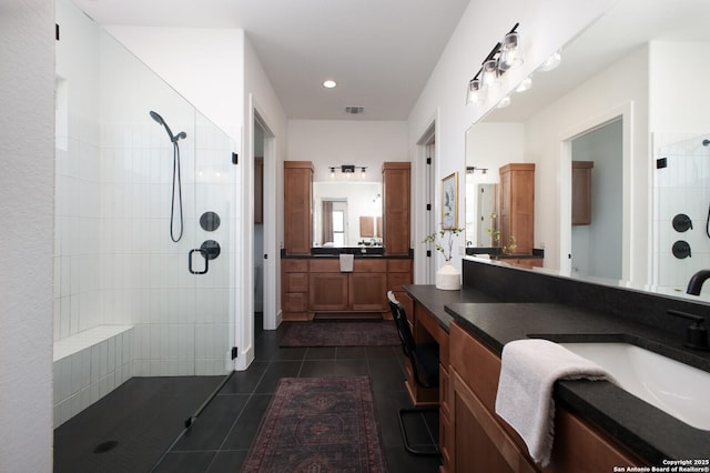 bathroom featuring vanity, tiled shower, and tile patterned floors