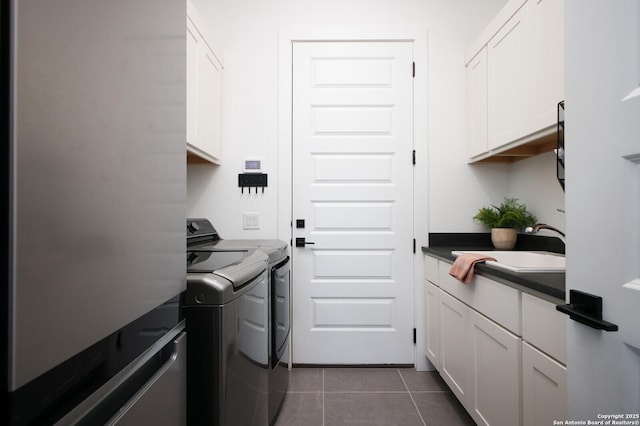 washroom featuring cabinets, separate washer and dryer, dark tile patterned floors, and sink