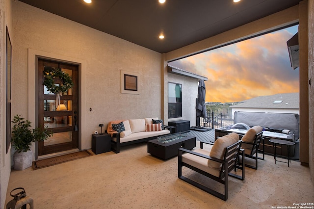 patio terrace at dusk with an outdoor living space with a fire pit