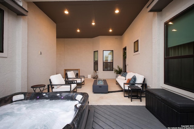 wooden deck featuring an outdoor hot tub and an outdoor hangout area