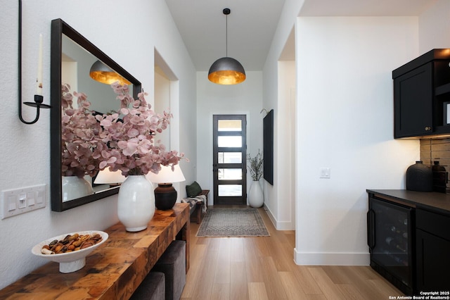 foyer entrance with wine cooler and light wood-type flooring