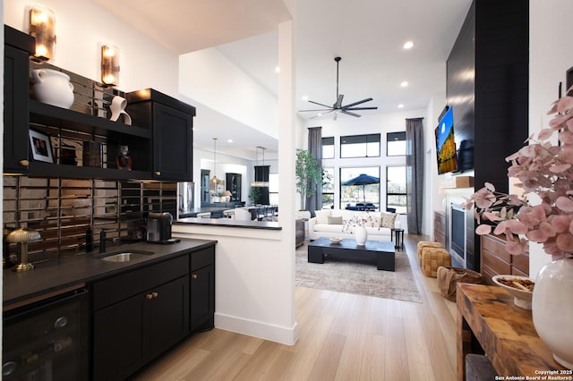 interior space with ceiling fan, kitchen peninsula, sink, and light hardwood / wood-style flooring