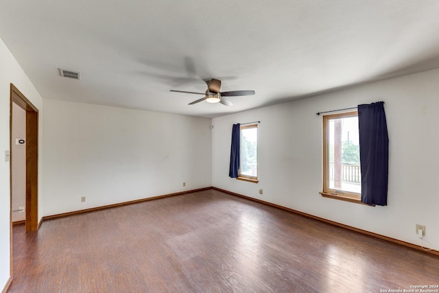 empty room with dark wood-type flooring and ceiling fan