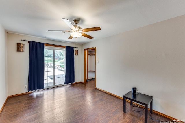 unfurnished room featuring dark wood-type flooring and ceiling fan