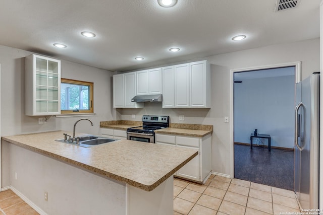 kitchen with sink, light tile patterned floors, appliances with stainless steel finishes, white cabinetry, and kitchen peninsula