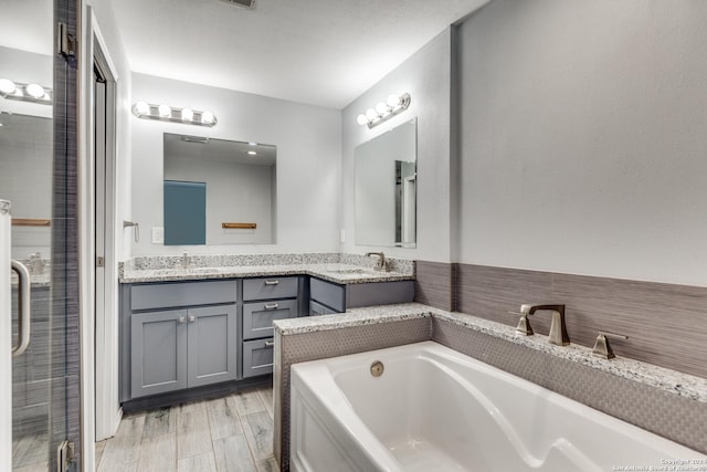 bathroom featuring vanity, hardwood / wood-style flooring, and shower with separate bathtub