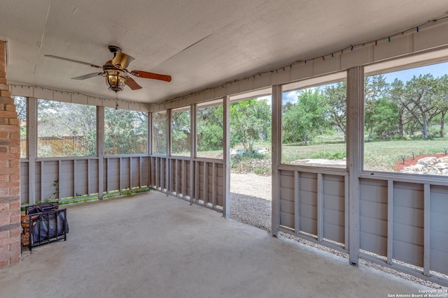 unfurnished sunroom with ceiling fan