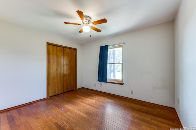 unfurnished bedroom featuring hardwood / wood-style flooring, ceiling fan, and a closet