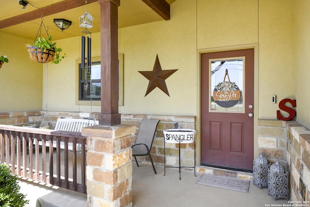 view of exterior entry with a porch