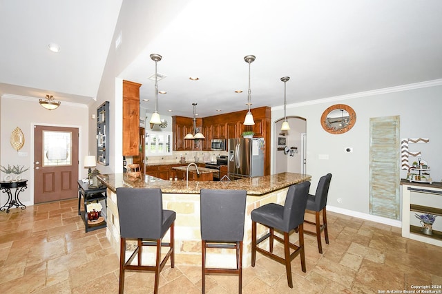 kitchen featuring crown molding, stone countertops, appliances with stainless steel finishes, a kitchen breakfast bar, and kitchen peninsula