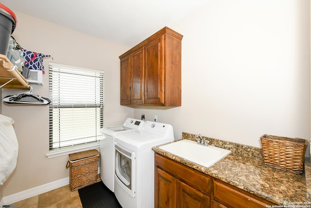 washroom with cabinets, plenty of natural light, washer and dryer, and sink