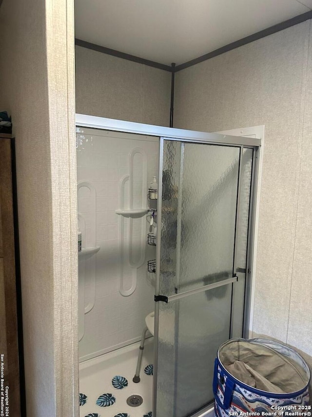 bathroom featuring ornamental molding and walk in shower